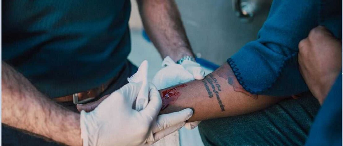 A trained first aider making wound first aid