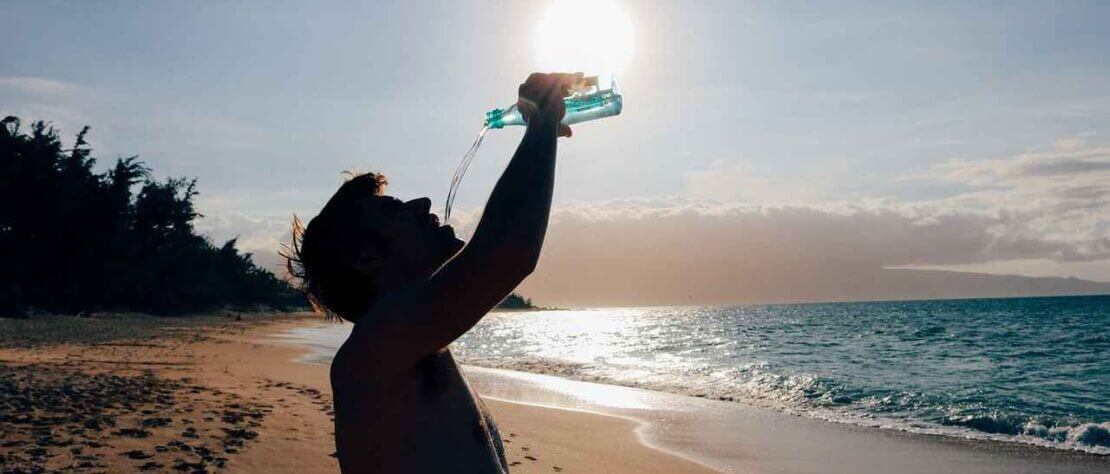 A man drinking water to protect yourself from heat stroke or sunstroke